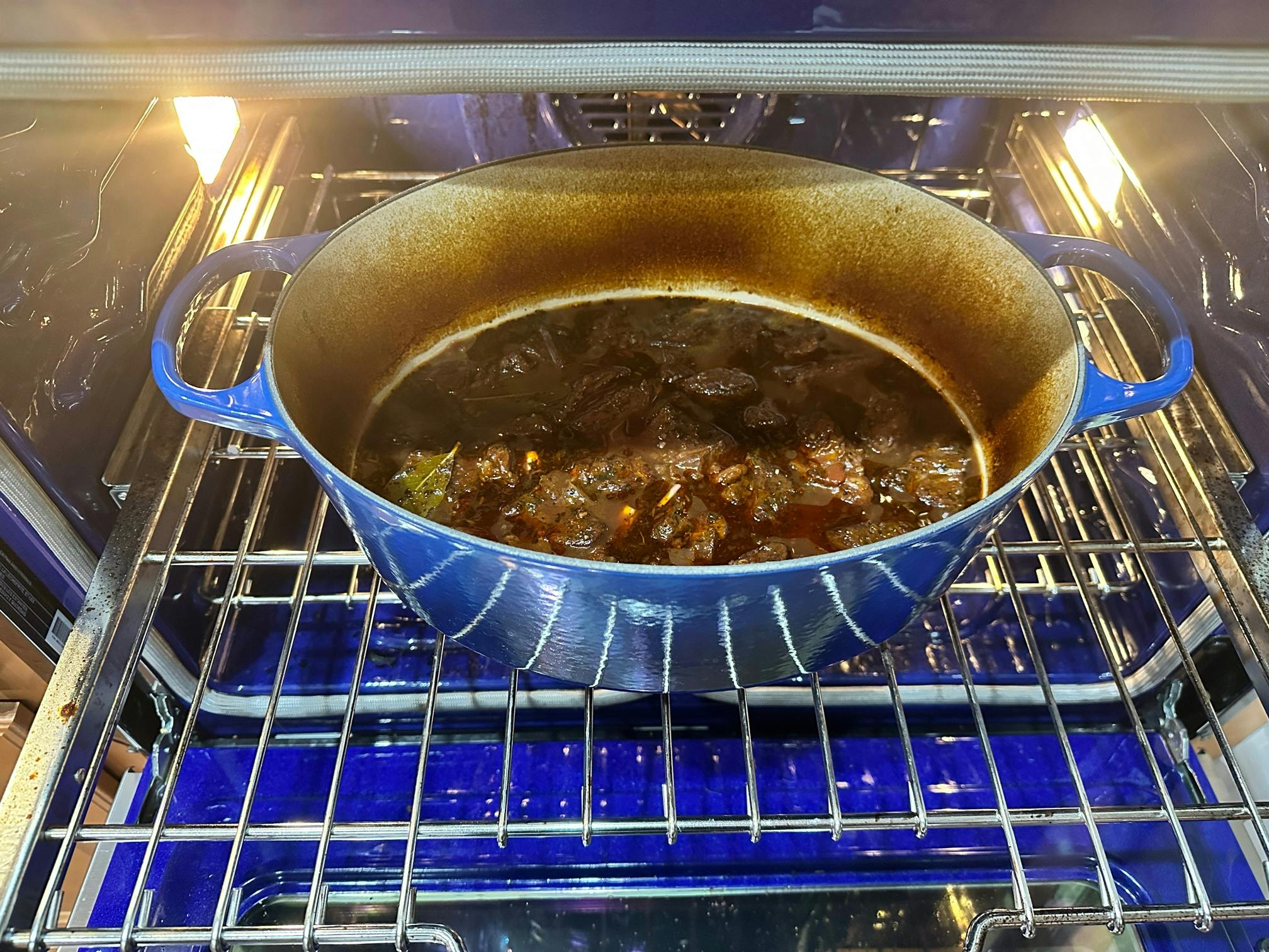 A Picture showing beef in a large Le Crusete pot in an oven